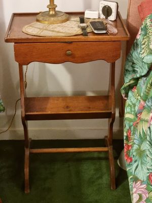 une petite table sur laquelle est posée une lampe, à côté d'un lit