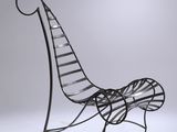 an iron bench with a curved back and a curved seat