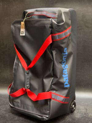 un gros plan d'un sac noir muni d'une bandoulière rouge