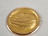 a gold coin with a picture of a boat on it