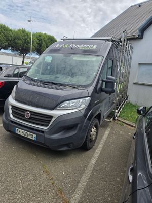 une camionnette noire garée sur un parking à côté d'un immeuble