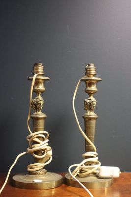 pair of antique brass candles on a wooden table with wires