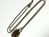 a necklace that has a small bird on it
