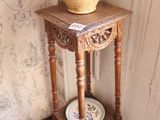 une table en bois sur laquelle est posé un vase