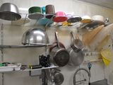 many pots and pans hanging on the wall in the kitchen