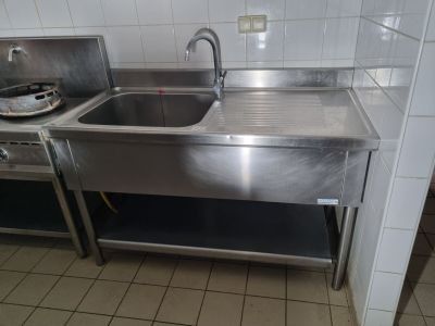 un évier en inox et une cuisinière dans une cuisine