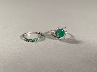 deux bagues ornées d'émeraudes, posées sur une table