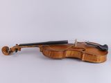 a close up of a violin sitting on a white surface