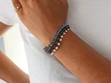 a woman that is wearing a bracelet with pearls on it