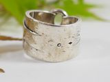 silver ring with a cat face on it sitting on top of a table