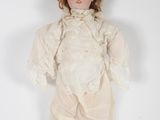 an antique doll with red hair and white dress on a white background