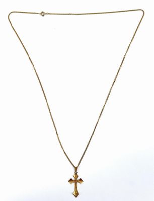 un collier en or avec un pendentif en forme de croix au bout d'une chaîne