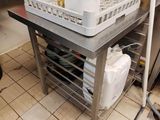 une table en métal sur laquelle est posé un panier contenant des ustensiles