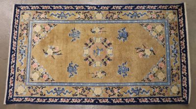 un tapis jaune avec une bordure bleue et des fleurs dessus