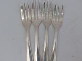 four forks that are sitting on a white surface