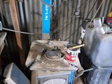 a small stove in the middle of a room with a lot of junk