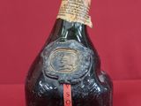 an old bottle of liquor sitting on top of a red table