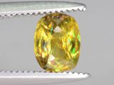 une image représentant un diamant jaune en train d'être taillé à l'aide d'une pince