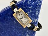 une image représentant une montre-bracelet posée sur une pierre bleue