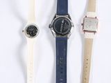 three watches are lined up in a row on a white surface