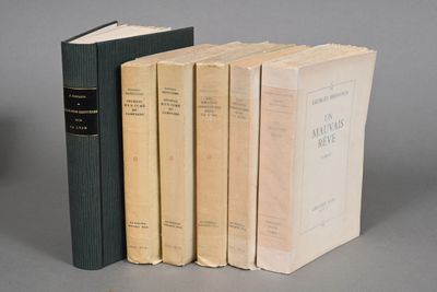 three books are stacked on top of each other on a gray surface