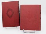 two red books sitting on top of each other on a white surface