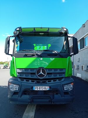 un camion vert garé devant un immeuble