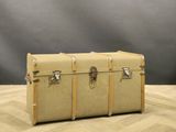 two trunks sitting on a wooden floor with a gray background