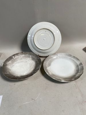 trois assiettes posées par terre les unes à côté des autres
