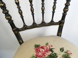 une chaise en bois noir dont l'assise est ornée d'un motif floral