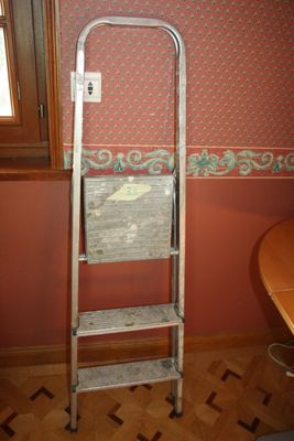 a ladder in the corner of a room next to a window