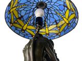 a statue of a woman holding a blue umbrella