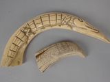 two pieces of carved ivory that are on a table