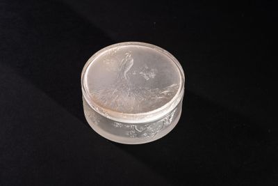 a small glass container with a lid on a black surface
