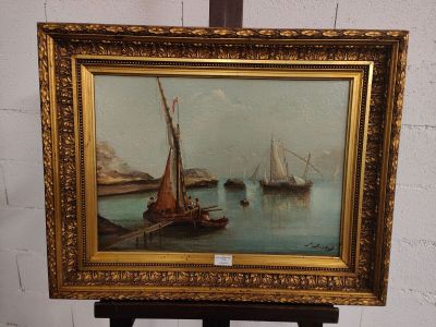 une photo d'un tableau posé sur un chevalet, avec un bateau dans l'eau