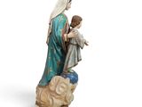 the statue of the virgin and child is holding a sheep
