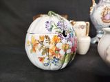 a white teapot with a floral design on it