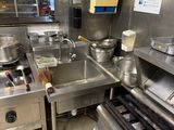 une cuisine équipée d'une cuisinière, d'un évier, d'une plaque de cuisson et d'autres appareils électroménagers