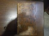 un vieux livre posé sur une table, sur lequel se projette une ombre