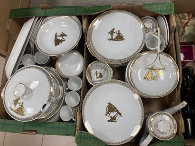 une boîte remplie d'assiettes et de tasses blanches et dorées