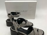 une paire de sandales noires et blanches posées sur une surface blanche