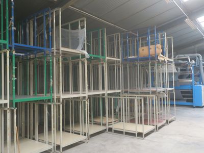 many shelves that are in a warehouse with a blue machine