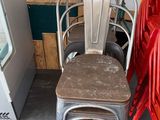 many red chairs and a metal chair in a room