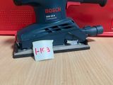 une ponceuse orbitale Bosch posée sur une table, avec son étiquette de prix