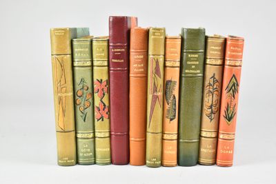 several old books are lined up in a row on a white surface