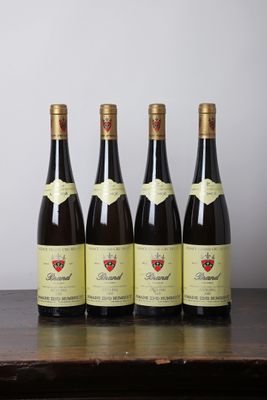 quatre bouteilles de vin sont alignées sur une table