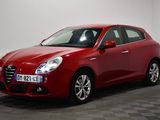 a red car is parked in a room with a checkered floor