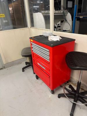 une photo représentant une armoire à outils et un tabouret dans un garage