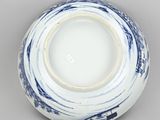 a blue and white bowl with a circular design on the rim