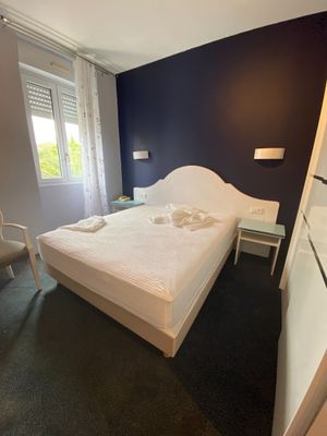a white bed sitting in a bedroom next to a window